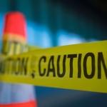 Yellow caution tape attached to traffic cone