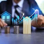 Real estate investment concept with person pointing on growth graph and coin stacking to get profit from property
